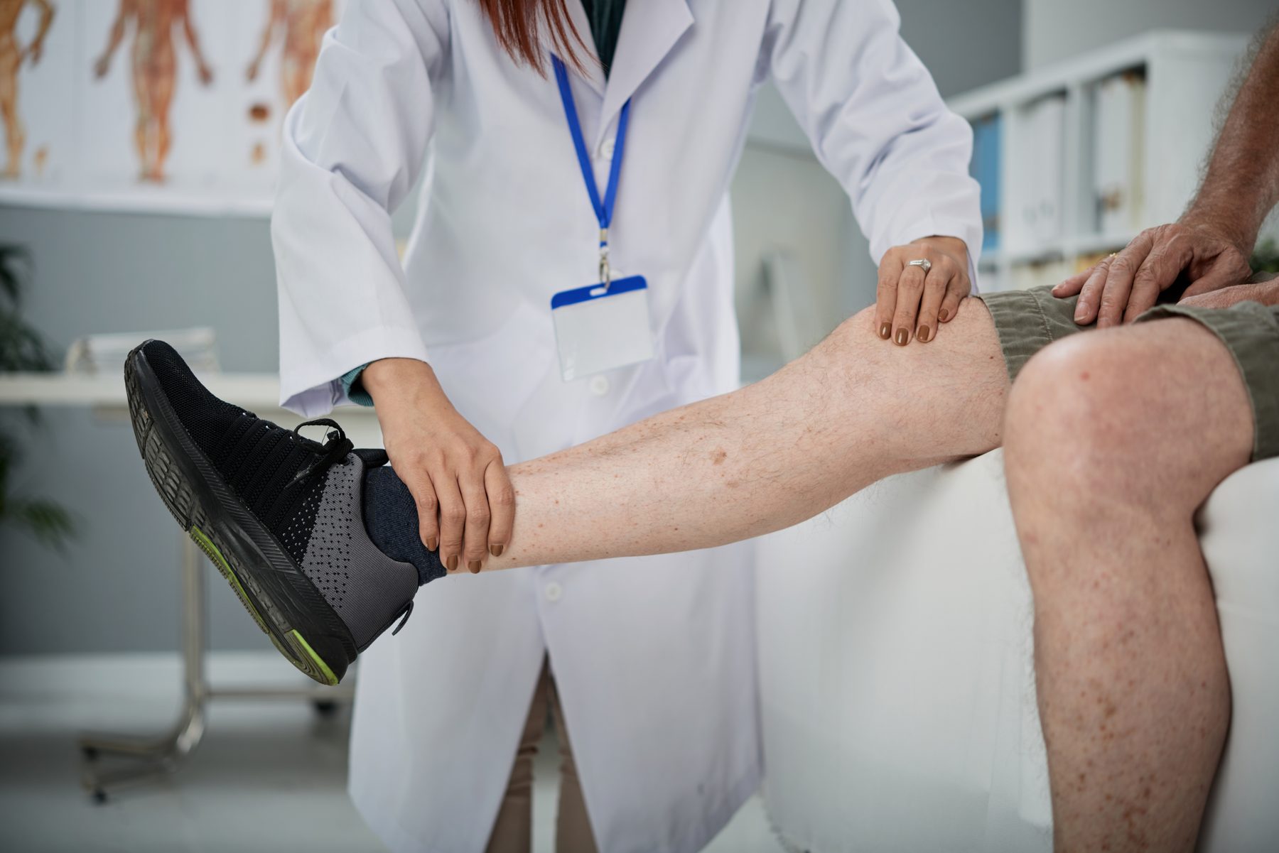 Podiatrist checking for pain in patient's leg