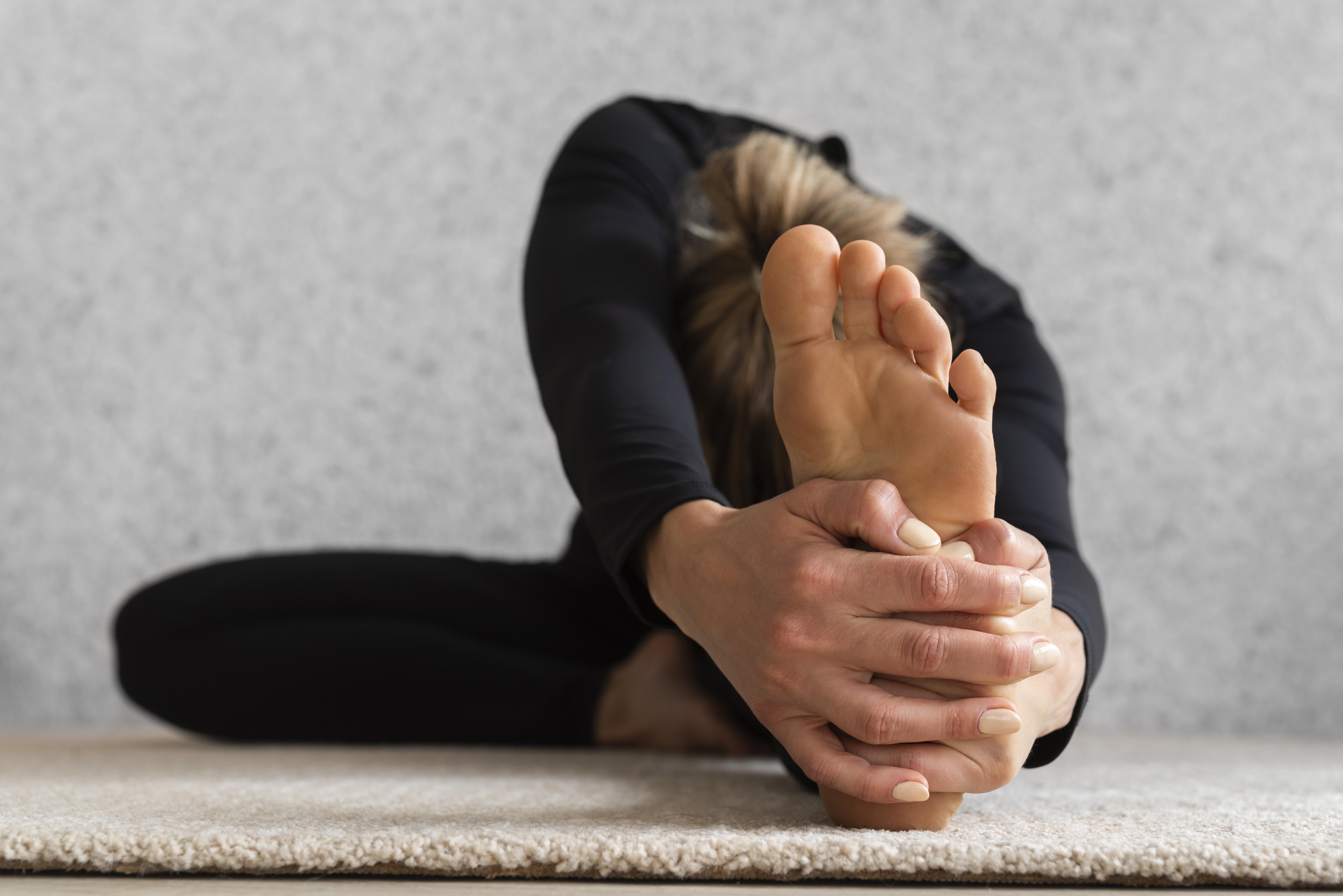 Woman stretching and holding her heel to relive pain